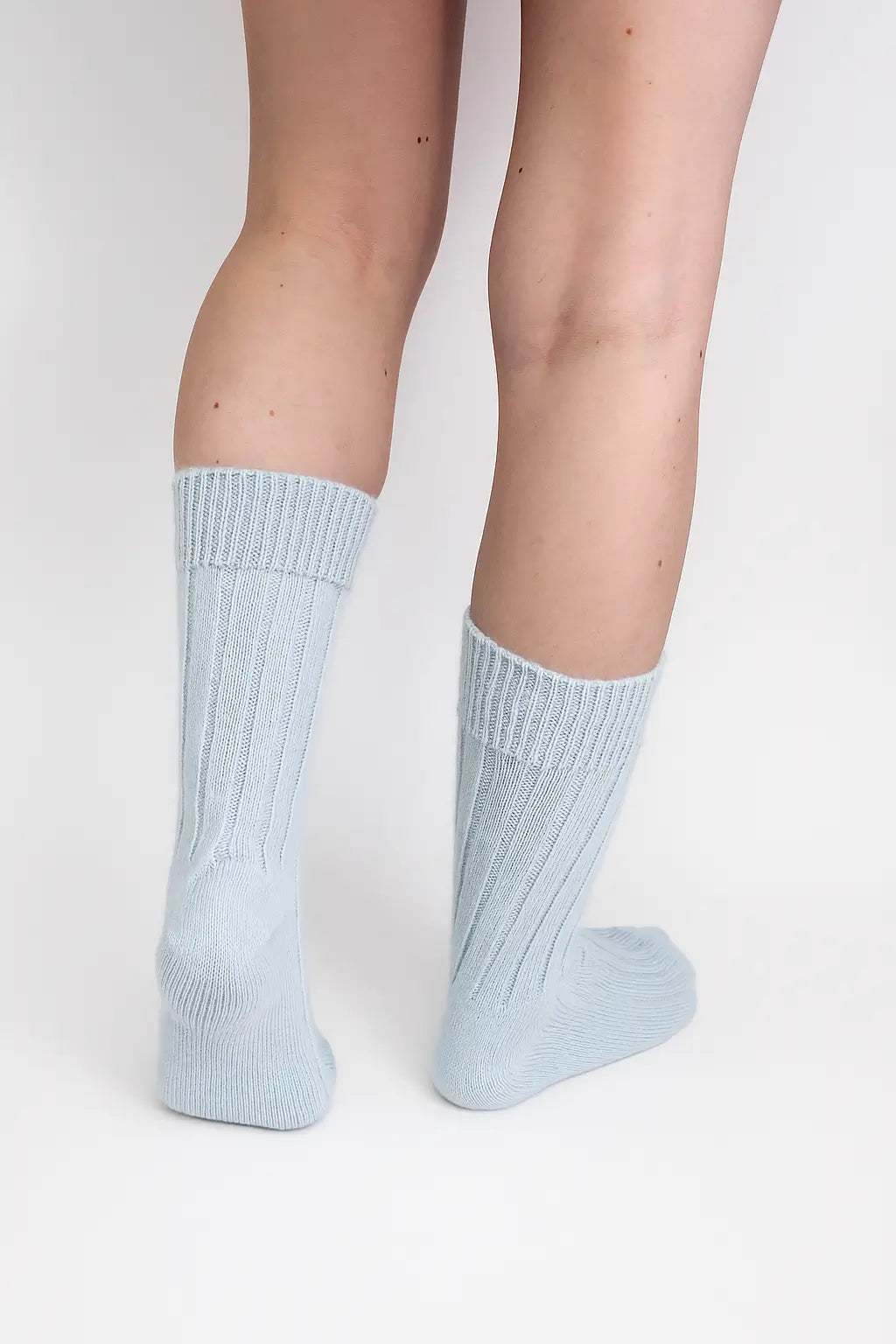 half british alpaca lounge socks in light blue, worn to show the ribbed knit detail and cosy alpaca texture against a white background