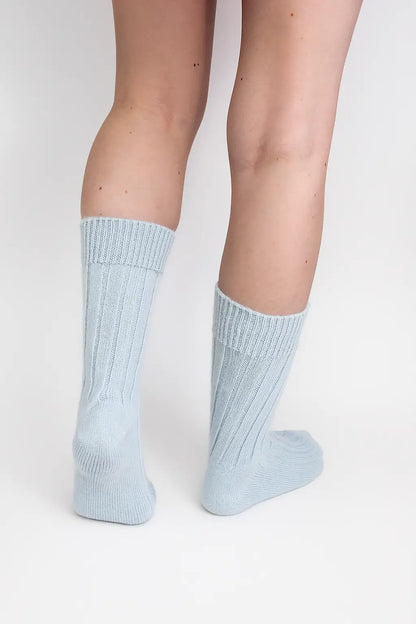 half british alpaca lounge socks in light blue, worn to show the ribbed knit detail and cosy alpaca texture against a white background