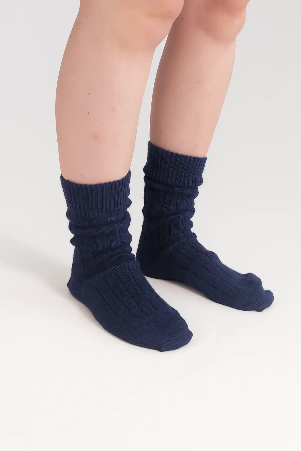 half british alpaca lounge socks in navy, worn slightly slouched to showcase the ribbed knit texture and soft alpaca wool against a white background