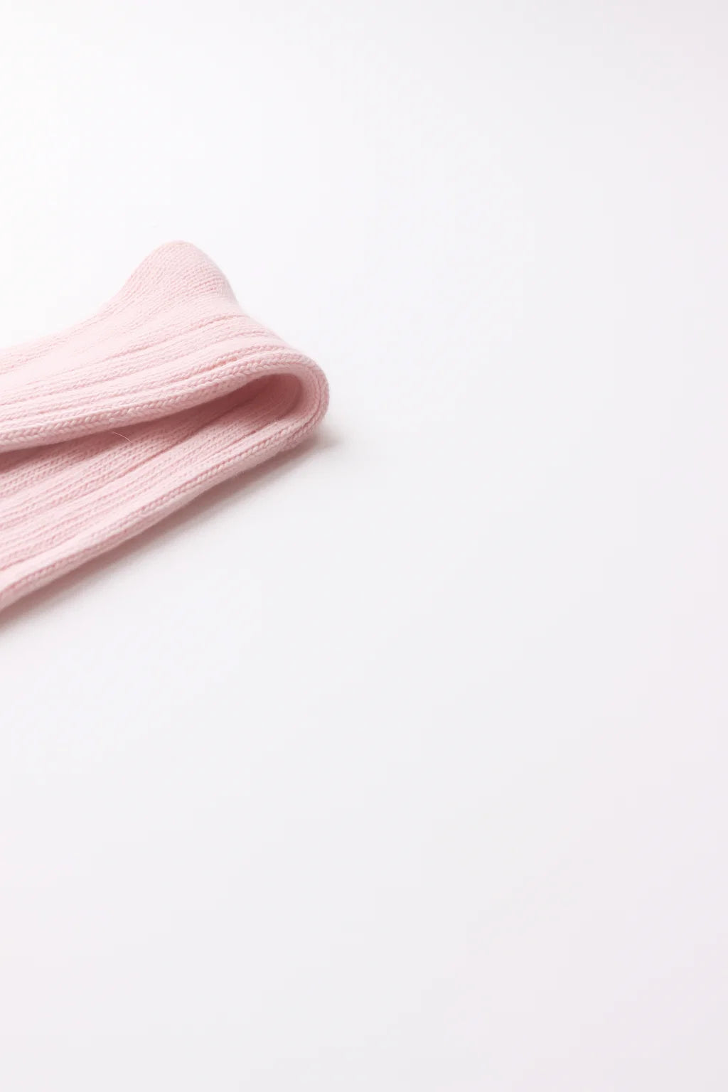 half british alpaca lounge sock in pink, folded neatly on a white background showing the ribbed knit pattern and soft alpaca texture