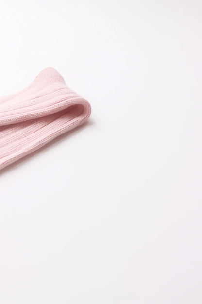 half british alpaca lounge sock in pink, folded neatly on a white background showing the ribbed knit pattern and soft alpaca texture