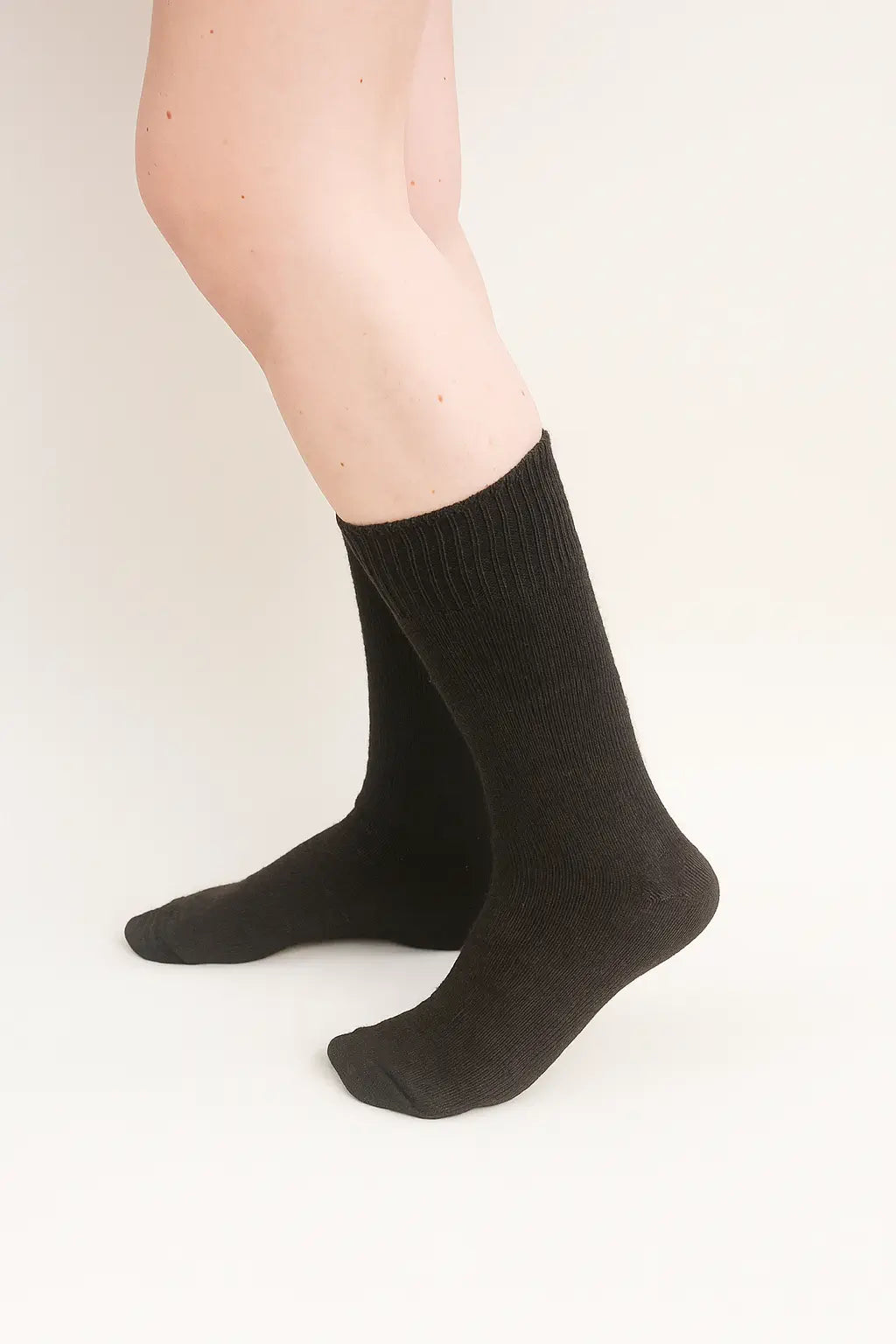half british everyday alpaca socks in bitter brown, worn to show the soft alpaca wool texture and fine ribbed design against a neutral background.