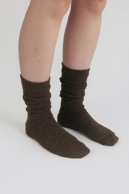 half british everyday alpaca socks in brown, worn and gently scrunched to show the ribbed knit texture and soft alpaca wool finish against a white background