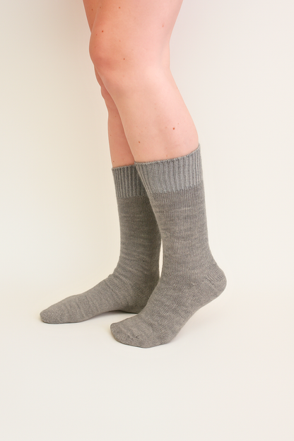 half british everyday alpaca socks in light grey, worn to show the fine ribbed knit and soft alpaca wool texture against a neutral beige background